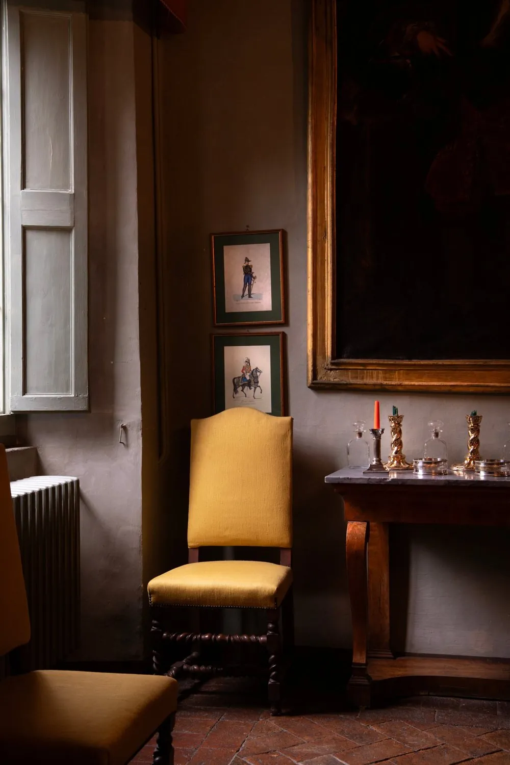 A shaded corner with a yellow chair and light from the window