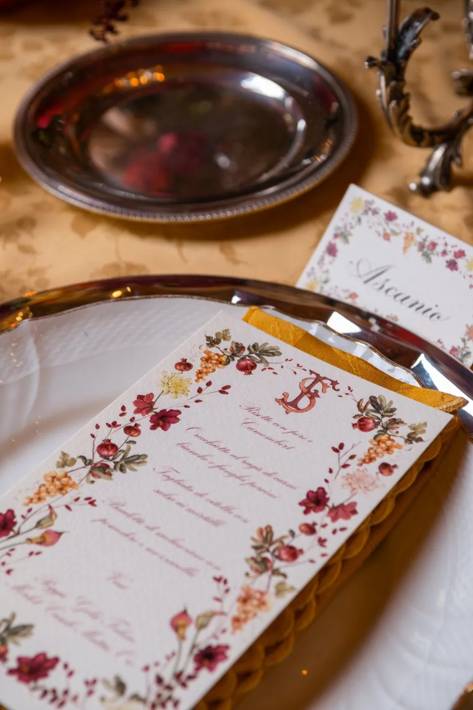 The illustrated menu with flowers and pomegranates resting on the plate