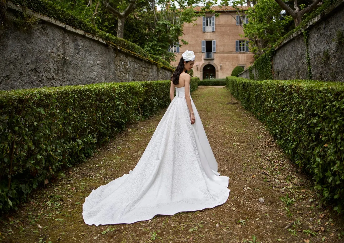A wedding dress on the avenue of the Italian garden, with the villa's façade in the background